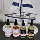 Air Freshener & Burning Oil set with four scented oil bottles beside a white and blue sailboat decor.
