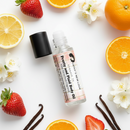 Pretty and plaid Body Oil by Cathy’s New Look, pink plaid label bottle with citrus fruits nearby.