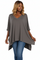 Oversize V-neck poncho with 1/2 sleeves in taupe gray, draped over jeans