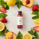 Sweet Strawberry Oil candle by Cathy's New Look; red fragrance oil bottle surrounded by lemons, peaches and strawberries.